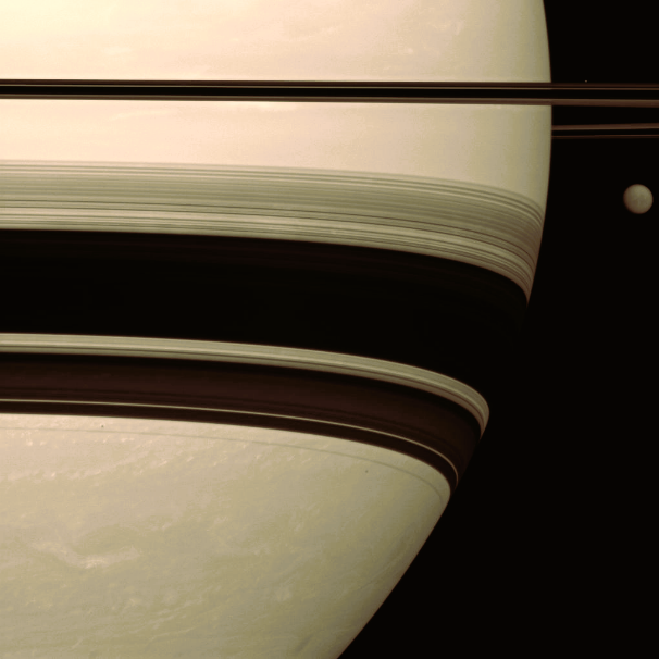 A closeup photo of the planet Saturn with its moon Titan